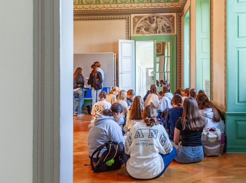 Schülerinnen sitzen im Stuhlkreis im historischen Klassenzimmer der Maria-Ward-Realschule Neuburg
