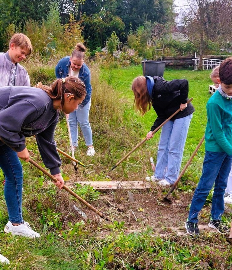 Schülerinnen und Schüler hacken Beete im Schulgarten der Maria-Ward-Realschule Neuburg