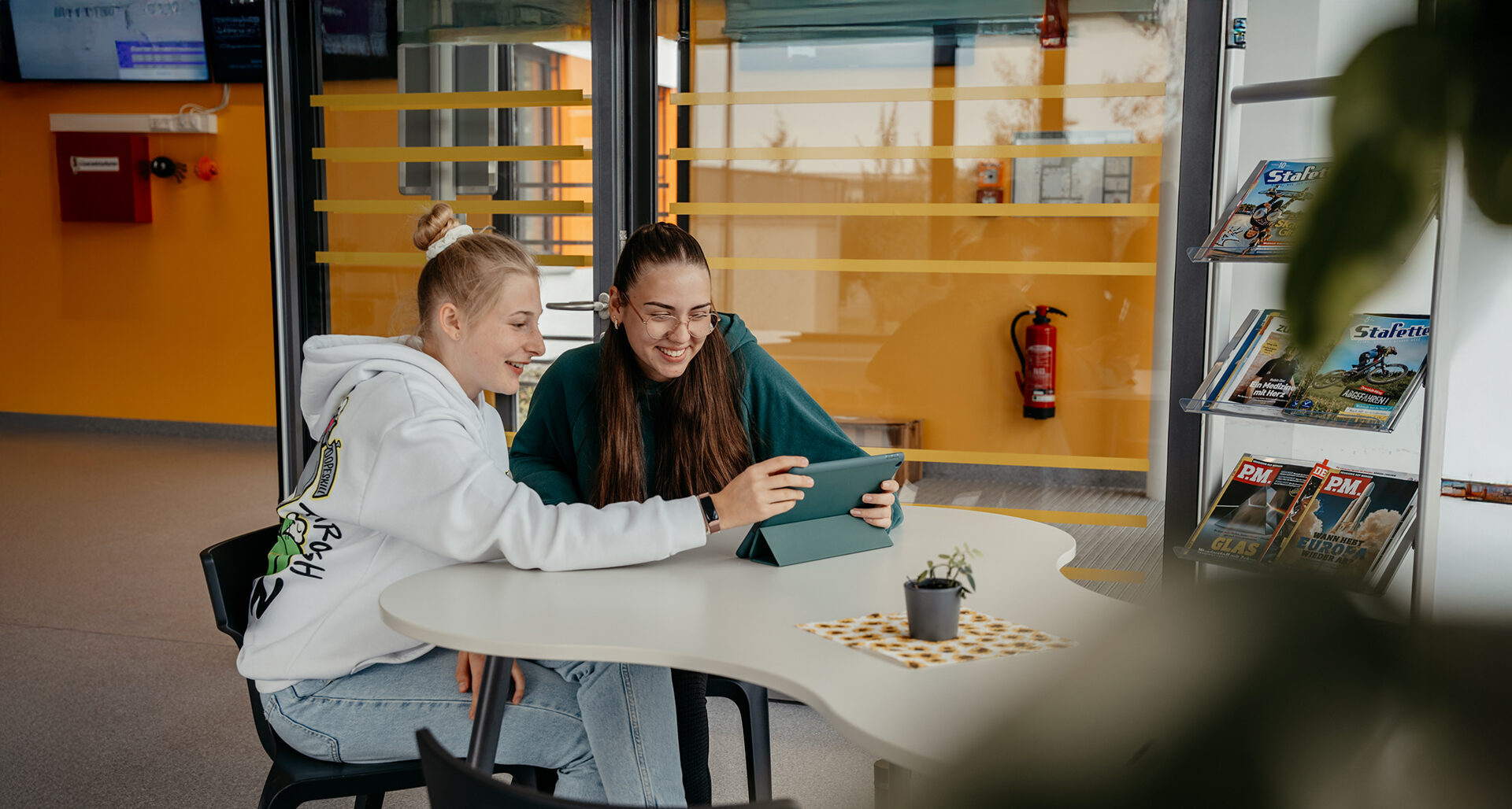 Zwei Schülerinnen arbeiten gemeinsam an einem Tablet